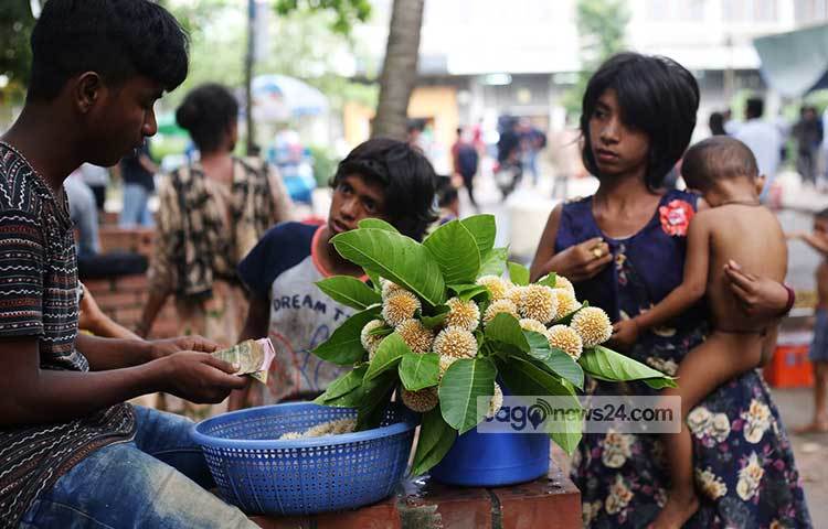 কদমফুল বিক্রি করছে এক কিশোর। বিক্রি ভালো হওয়ায় বেশ আনন্দিত এই ফুল বিক্রেতা। ছবি: মাহবুব আলম